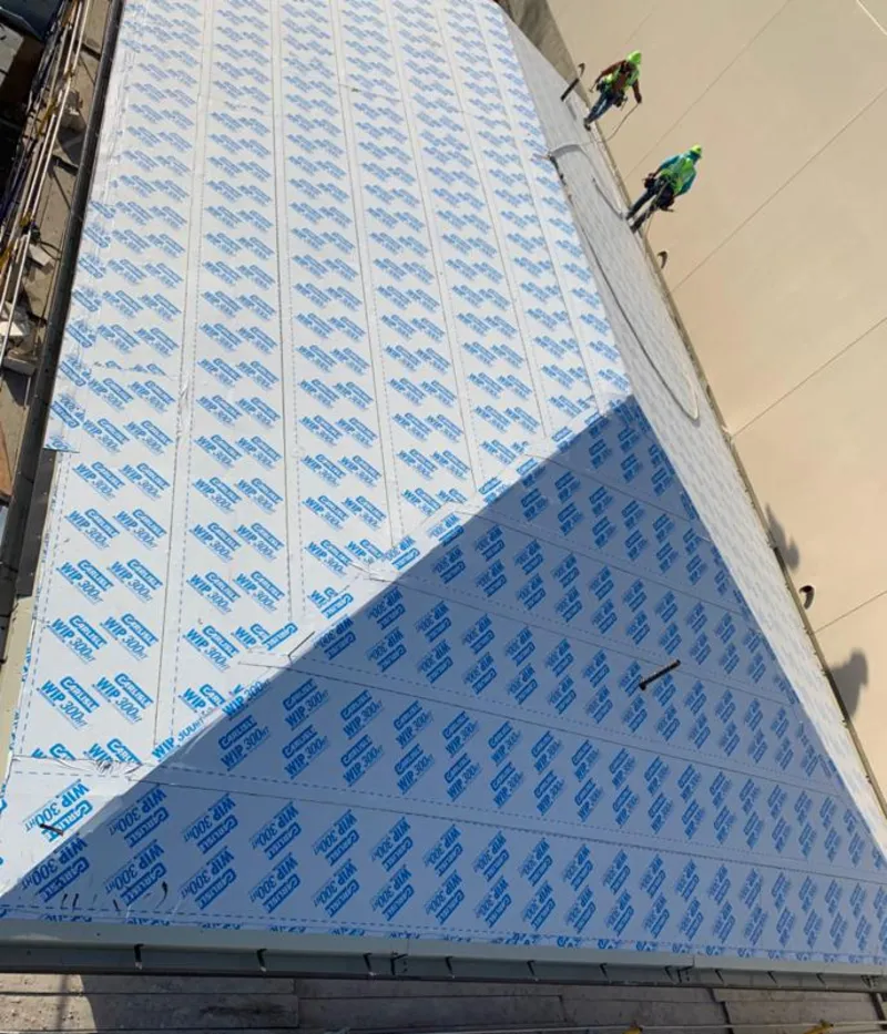 Professional roofers installing underlayment on a metal roof in Otsego